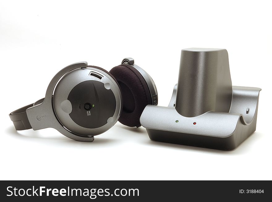 An image of cordless headphone sitting next to thier base unit on white background. An image of cordless headphone sitting next to thier base unit on white background