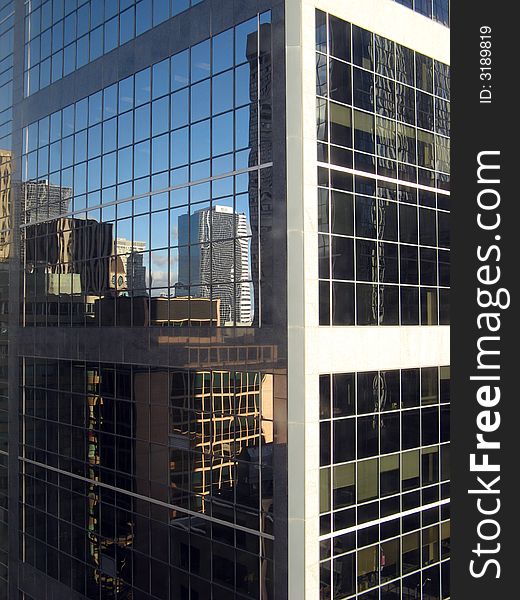 A glass constructed skyscraper with reflection of other buildings. A glass constructed skyscraper with reflection of other buildings