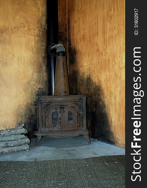 Old wood burning stove with soot marks on the surrounding walls