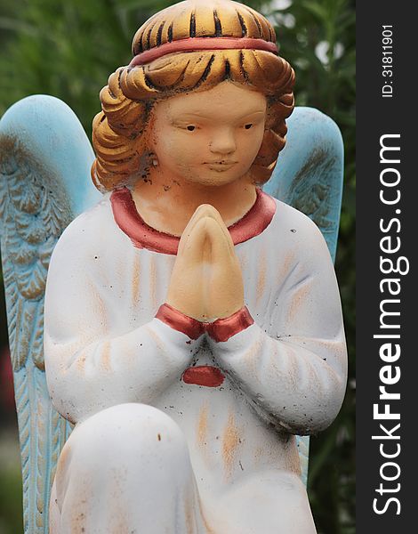 Figure of a praying angel in the cemetery