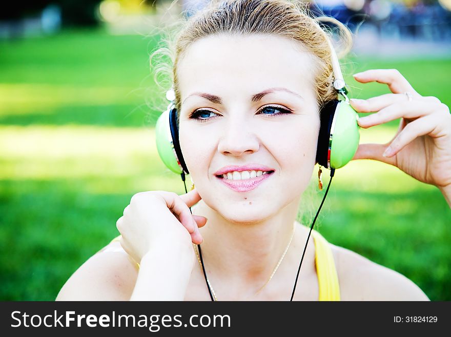 Young cheerful woman enjoing the music outdoors