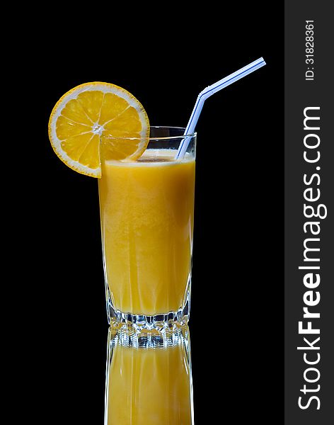 A glass of orange juice with reflection on black background. A glass of orange juice with reflection on black background