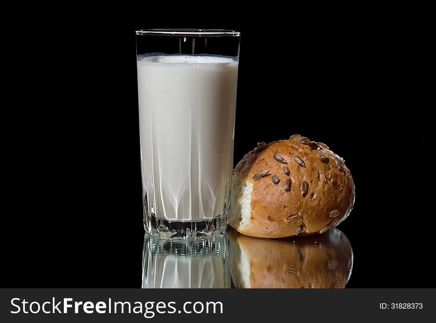 A glass of milk and muffin breads with reflection