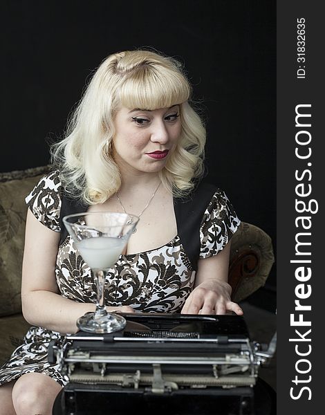 Portrait of a beautiful young woman with blond hair and brown eyes typing on a vintage typewriter. Portrait of a beautiful young woman with blond hair and brown eyes typing on a vintage typewriter.