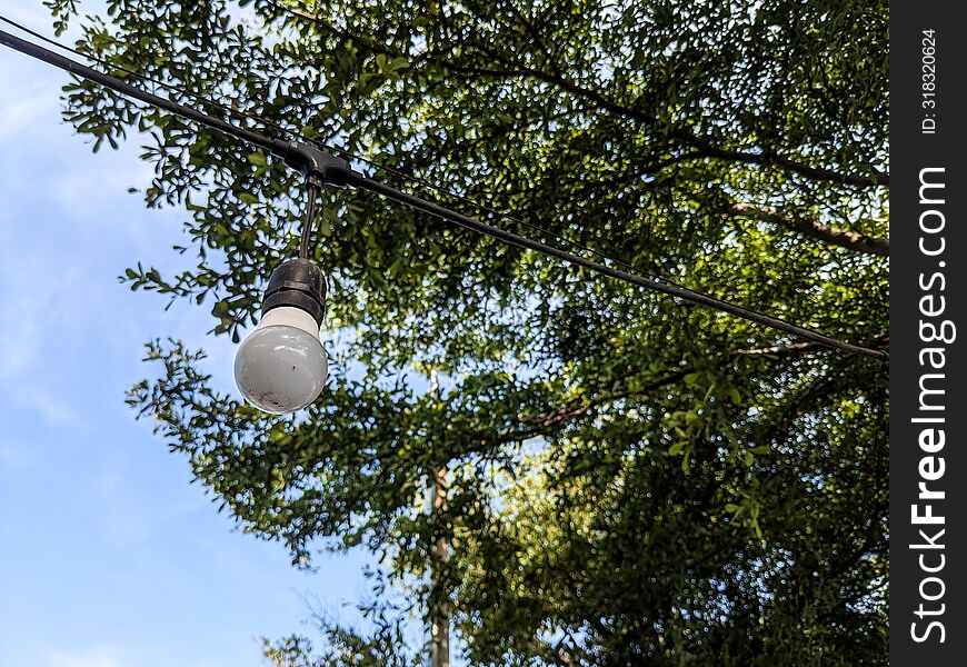 White hanging lamp in the garden with sky and trees as background