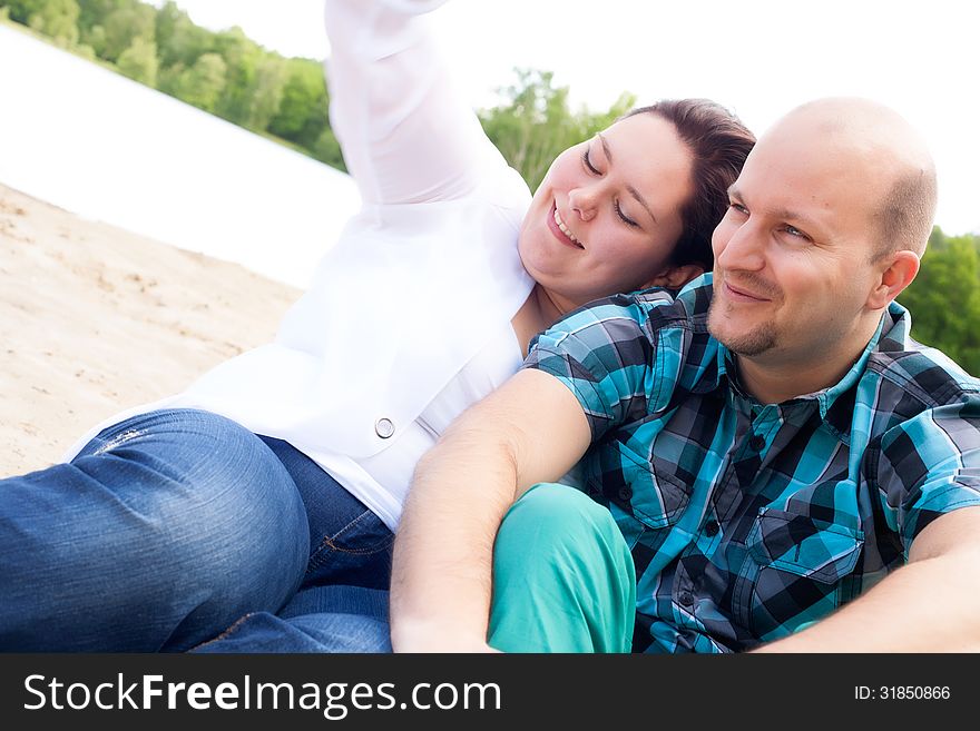 Happy young couple is having fun on a windy park beach. Happy young couple is having fun on a windy park beach