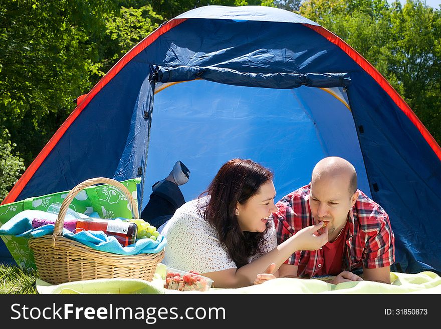 Happy young couple is relaxing on a camping. Happy young couple is relaxing on a camping