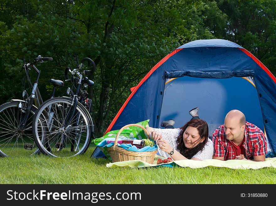 Happy young couple is relaxing on a camping. Happy young couple is relaxing on a camping