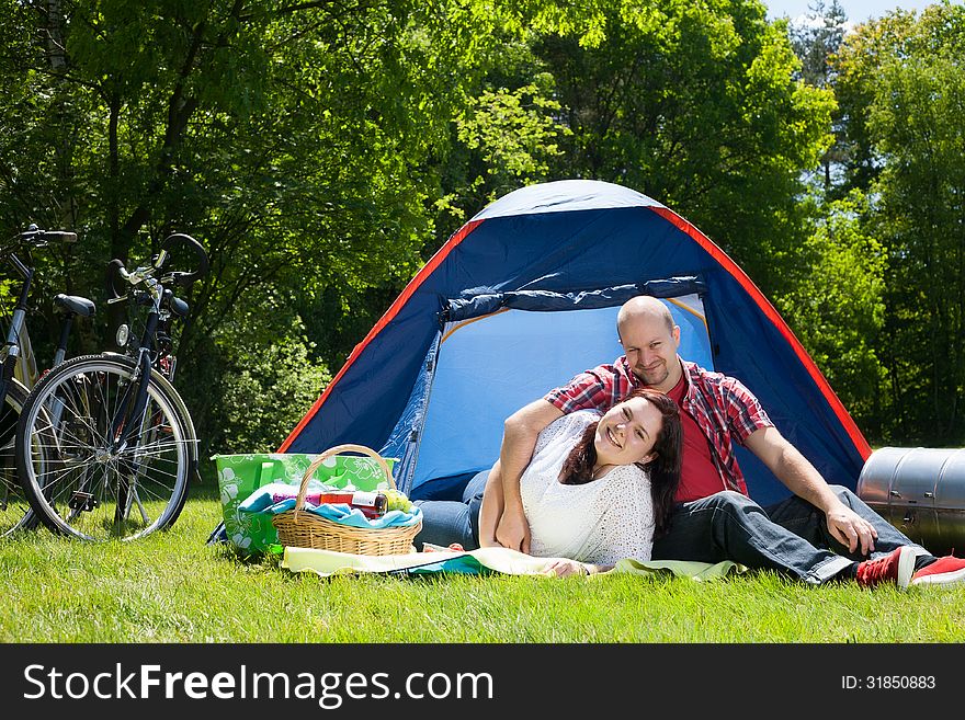 Happy young couple is relaxing on a camping. Happy young couple is relaxing on a camping