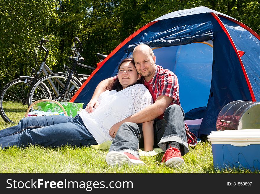 Happy young couple is relaxing on a camping. Happy young couple is relaxing on a camping