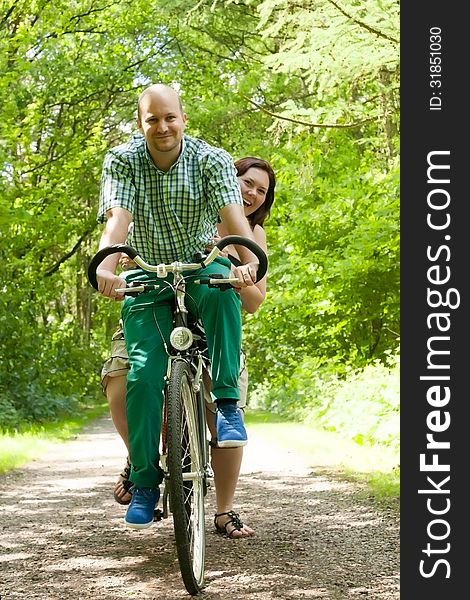 Happy young couple is taking a ride on a bicicle. Happy young couple is taking a ride on a bicicle