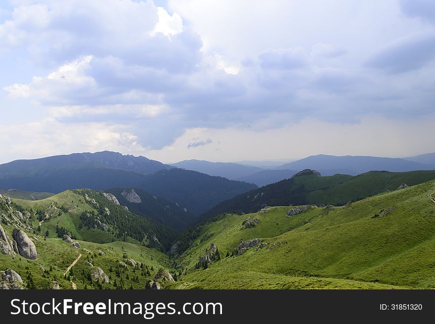 Summer mountain route, partly with storm clouds