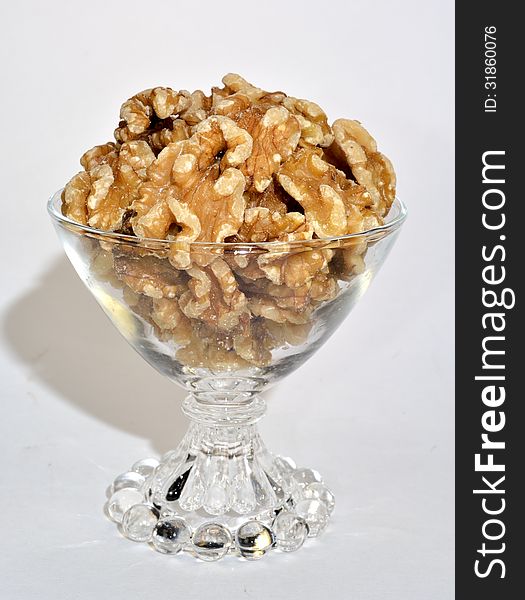 A small glass bowl of shelled walnuts.