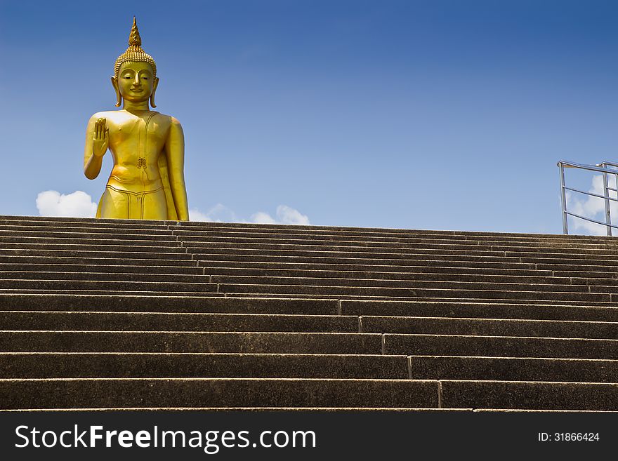 Big  Golden Buddha Statue On Blue Background.