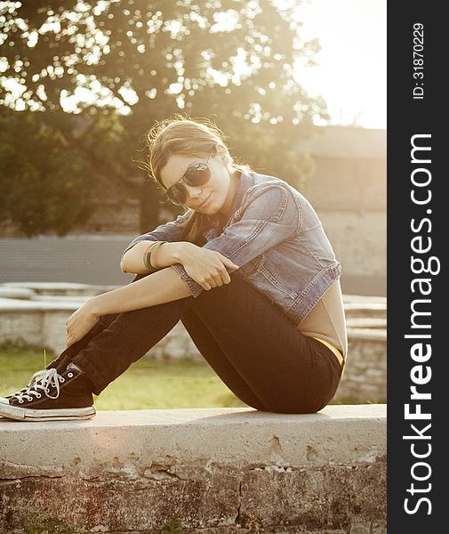 Young beautiful girl in sneakers, vertical, sitting. Young beautiful girl in sneakers, vertical, sitting