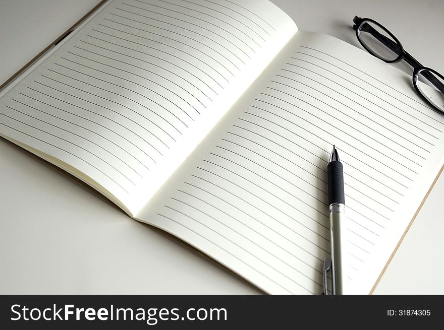 Blank page notebook paper with pen and glasses