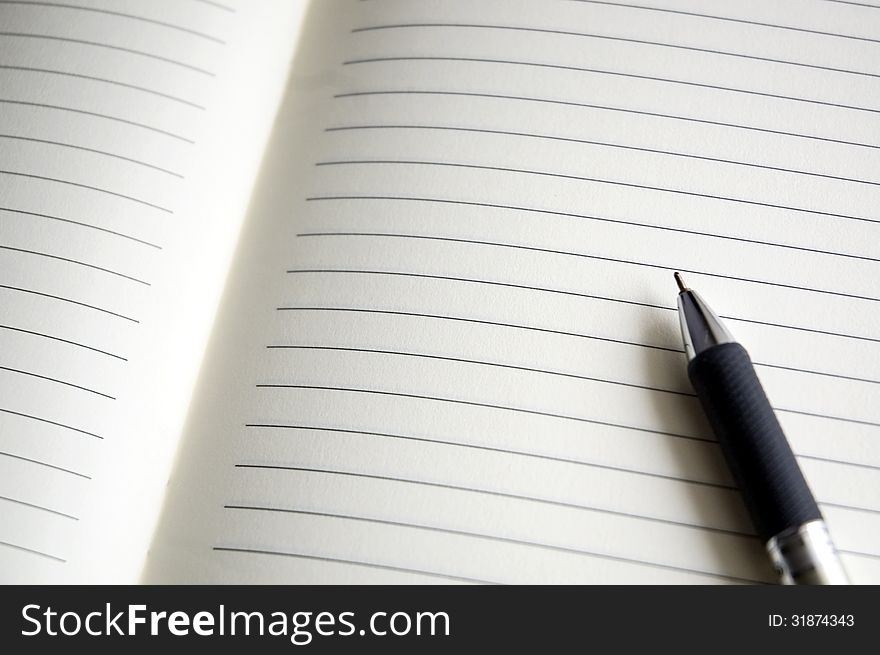Open blank pages of notebook with pen. Open blank pages of notebook with pen