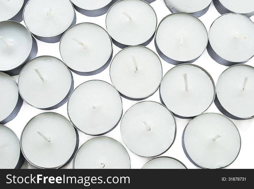 A lot of white tea lights on white background
