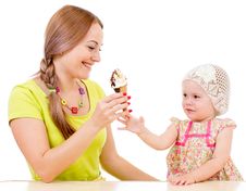 Mother Giving Ice Cream To Little Girl Sitting At Table Stock Photography