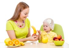 Mother Feeding Little Girl With Healthy Food Sitting At Table Stock Images Mother Feeding Little Girl With Healthy Food Sitting At Table Stock Images