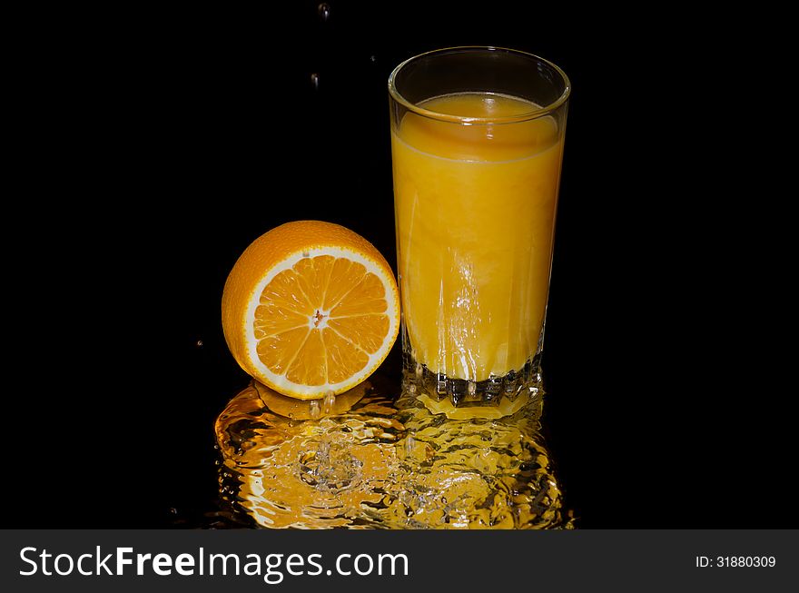 Freshly squeezed orange juice on a black background. Freshly squeezed orange juice on a black background