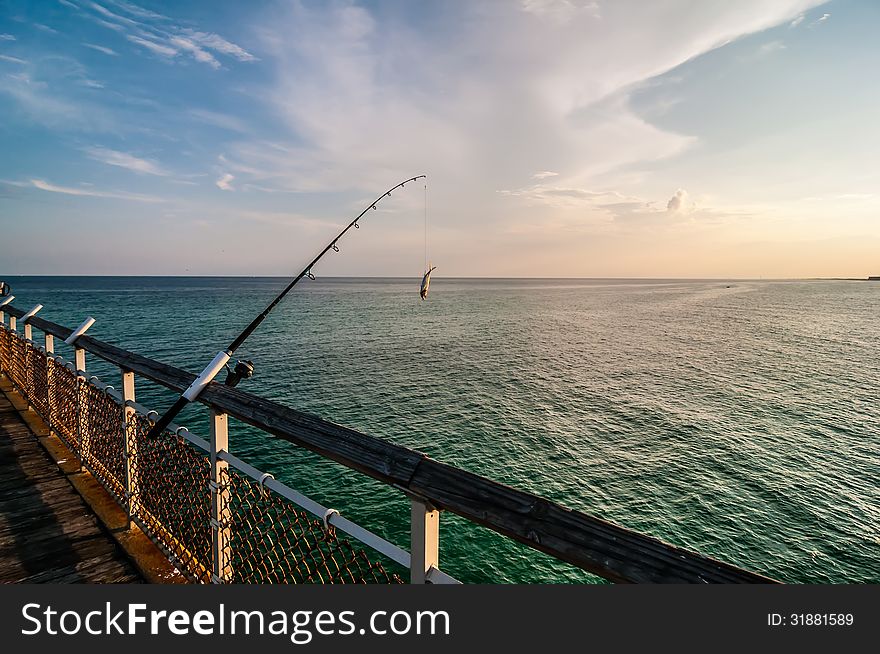 Fishing of an ocean pier at sunset in gulf of mexico