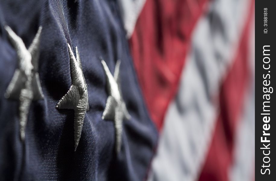 Horizontal close up shot of American flag. Shot diagonally with focus on a white star in blue field with blurred red and white stripes. Horizontal close up shot of American flag. Shot diagonally with focus on a white star in blue field with blurred red and white stripes