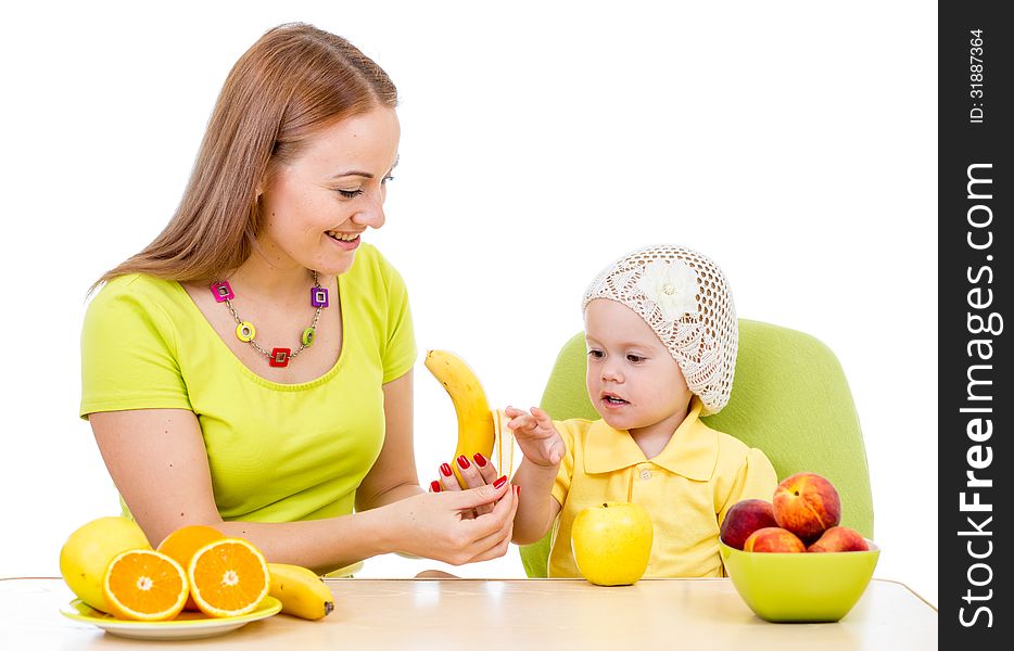 Mother feeding little girl with healthy food sitting at table isolated on white