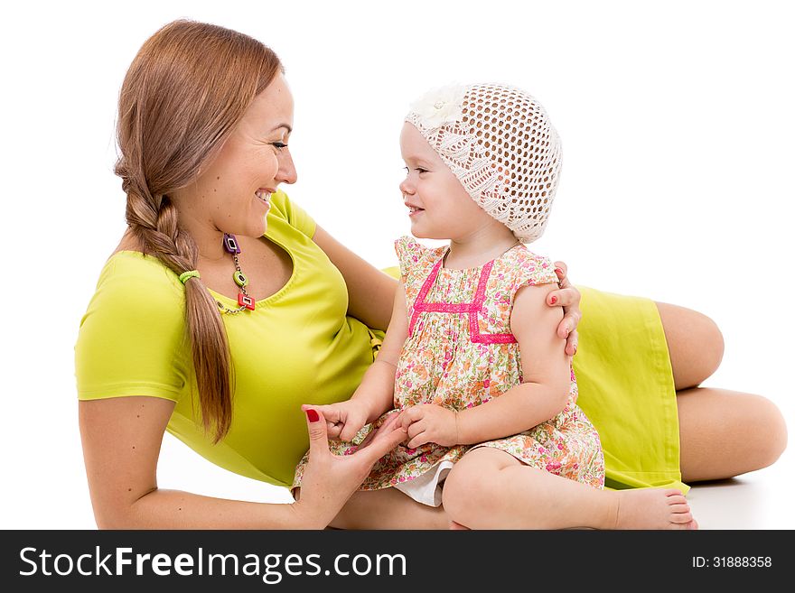 Happy mother and little girl lying on white floor and smiling