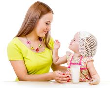 Mother Giving Milk Glass To Little Girl Sitting At Table Stock Images Mother Giving Milk Glass To Little Girl Sitting At Table Stock Images