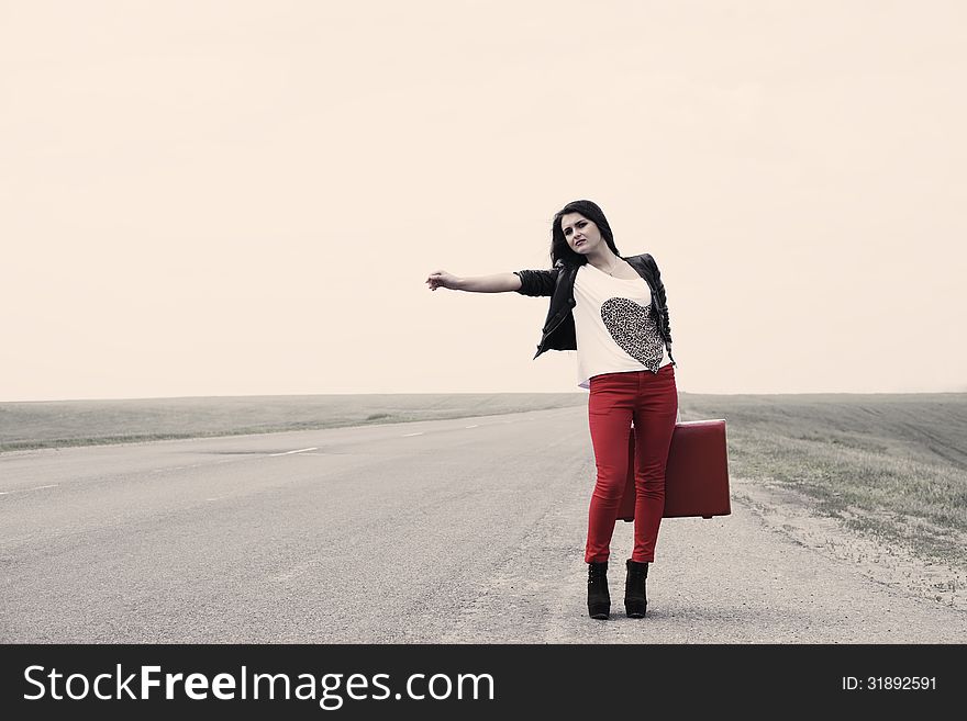 Girl Standing On Road With Suitcase Looks For Fellow Traveler