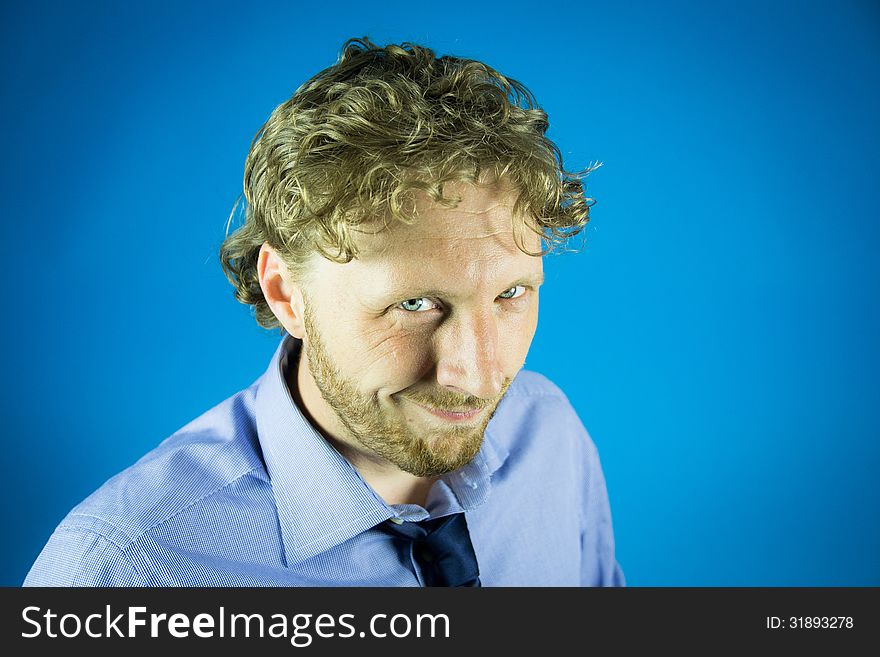 Knowing look of a business man with tie on blue background