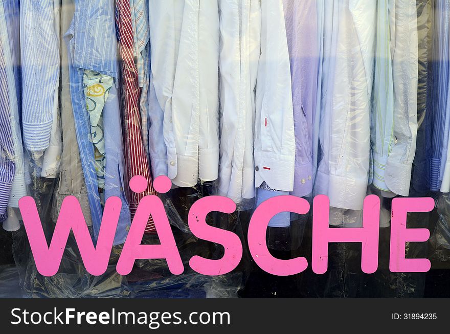 Sign And Shirts In The Window Of A Vintage German Laundromat