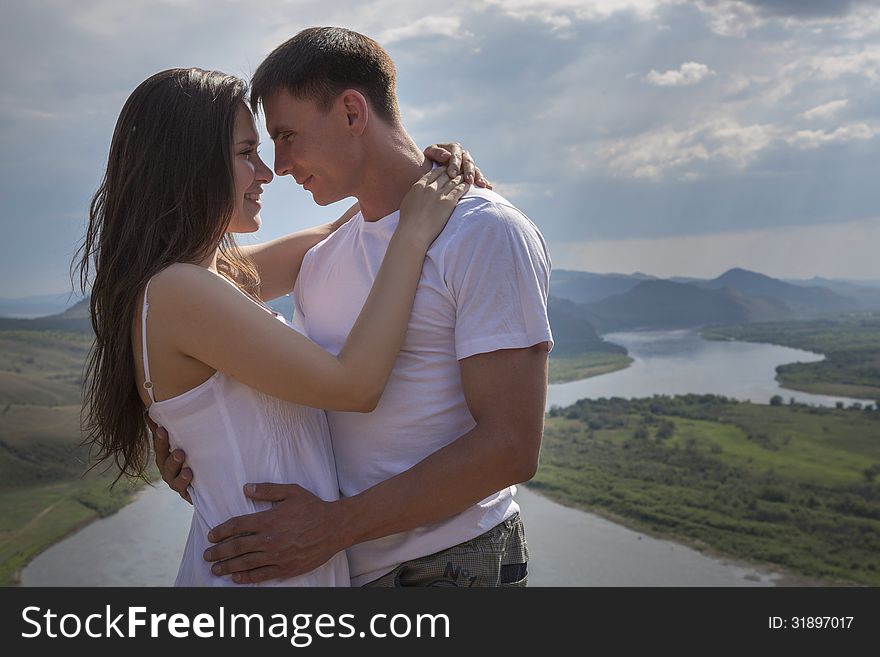 Happy Young Couple hugging in mountains with river on background