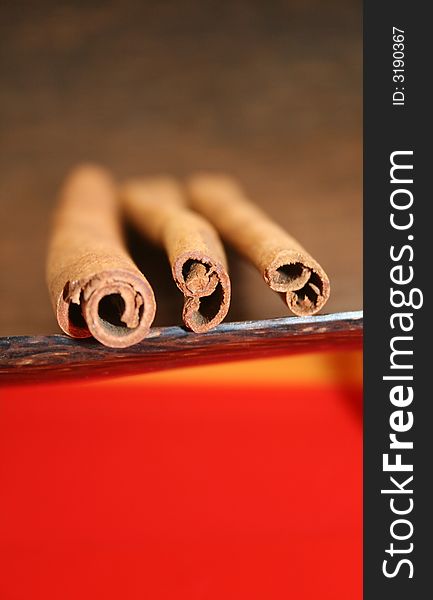 Three cinnamon sticks on the wooden plate