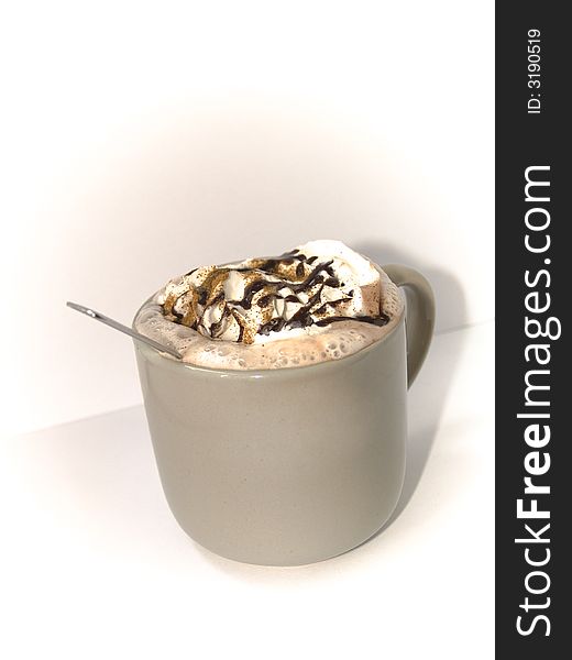 A mug topped with whipped cream and chocolate.