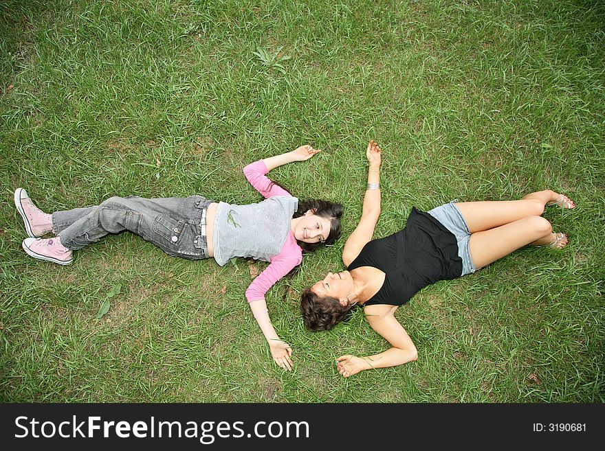 Mother and daughter-teenager lie on the grass