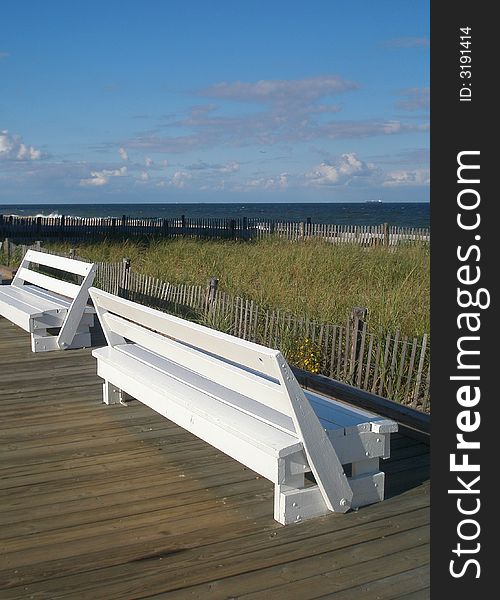 Two benches on the boardwalk off the beach