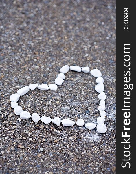 White stones on asphalt. Heartshaped. White stones on asphalt. Heartshaped.