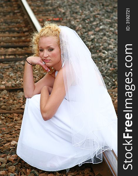 Emotional bride sitting on the tracks. Emotional bride sitting on the tracks.