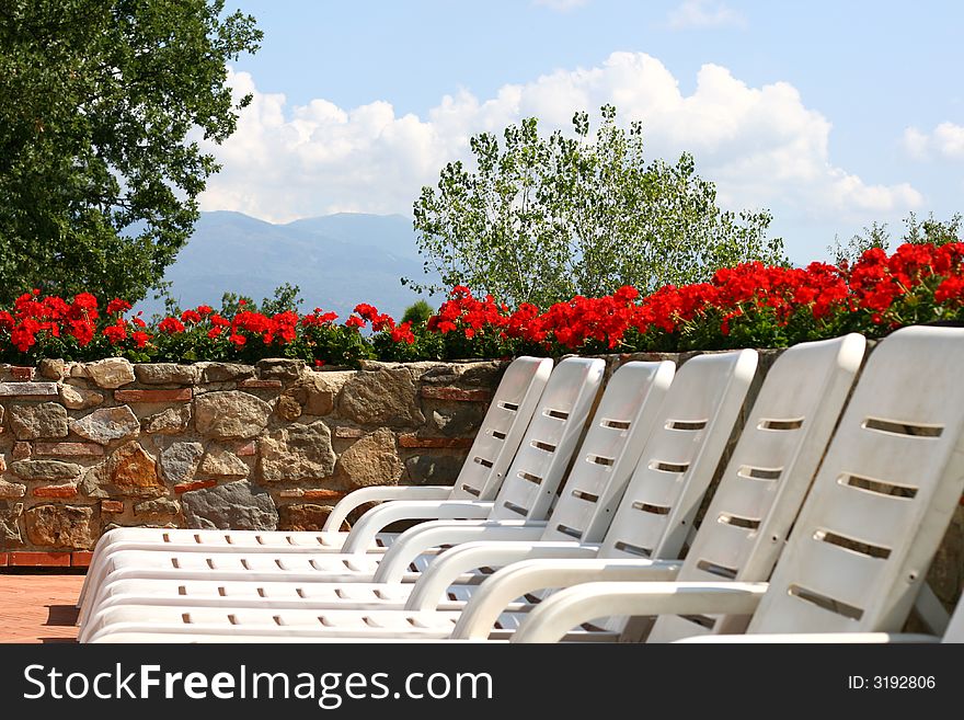 A row of empty pool chairs.