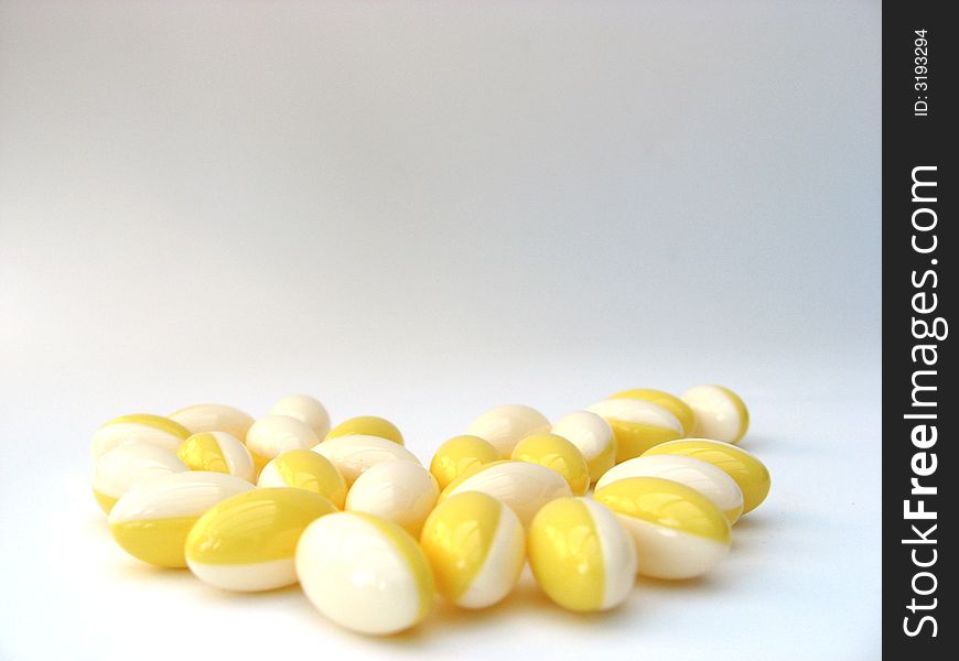 White and yellow pills on a white background