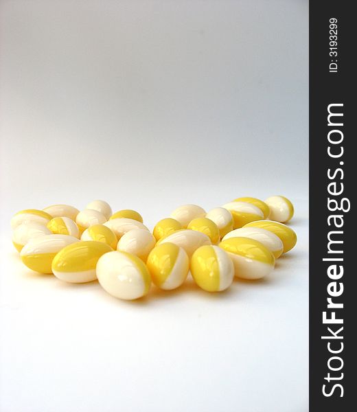 White and yellow pills on a white background