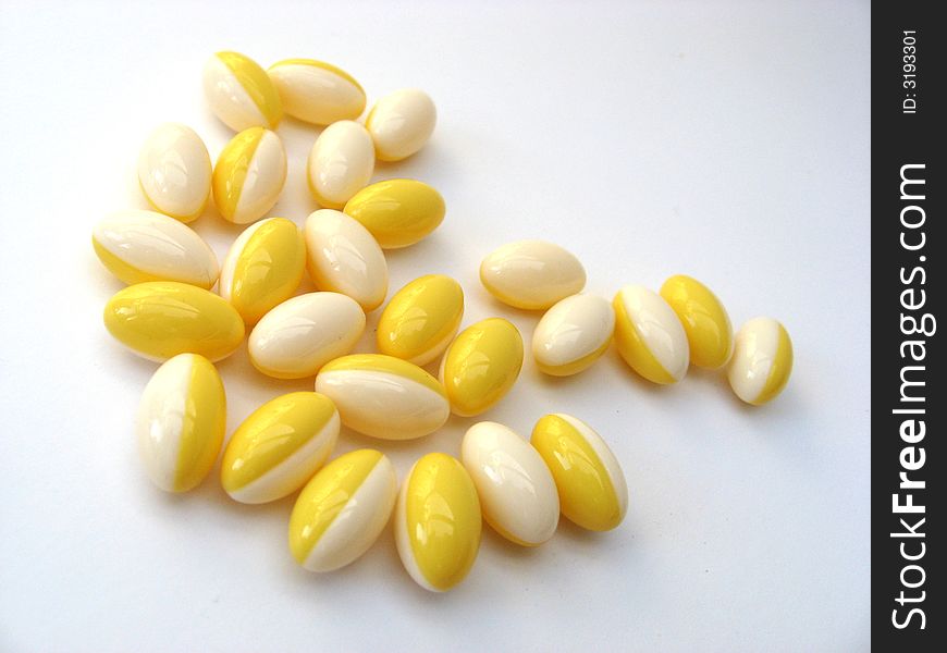 White and yellow pills on a white background