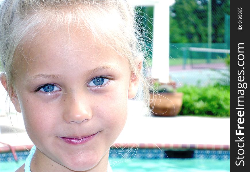 A cute child with long blonde hair and big baby blue eyes wearing a tropical print dress. A cute child with long blonde hair and big baby blue eyes wearing a tropical print dress.