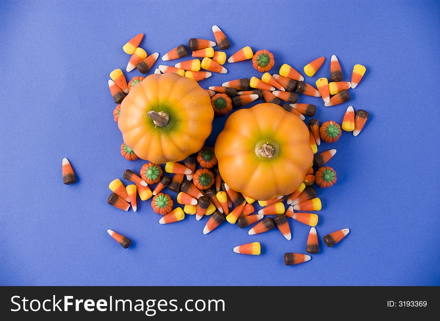 Two little pumpkins surrounded by colorful candy. Two little pumpkins surrounded by colorful candy.