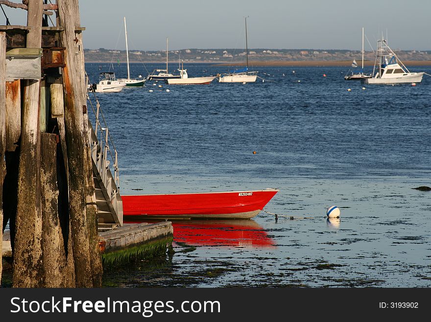 Red boat at low tide in Cape Cod near the wharf