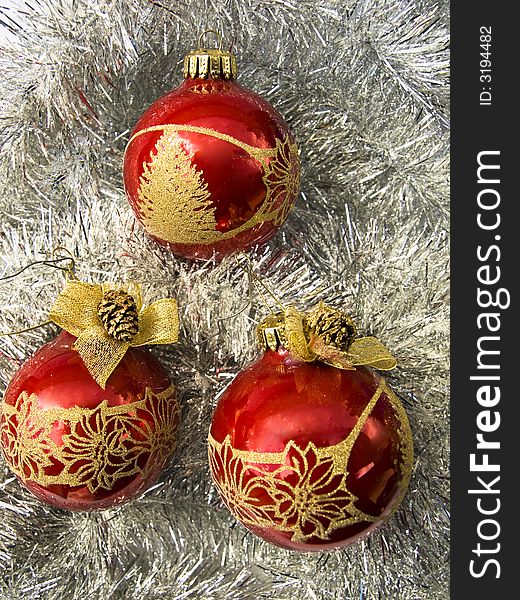 Three red Christmass balls with golden decor on a silver decoration. Three red Christmass balls with golden decor on a silver decoration