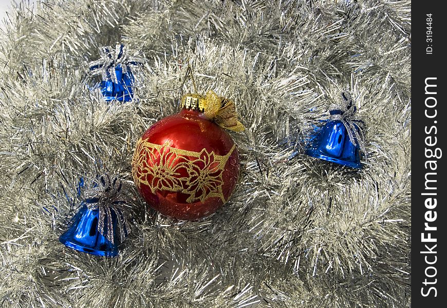 Red glass ball and three blue bells over silver Christmas decoration. Red glass ball and three blue bells over silver Christmas decoration