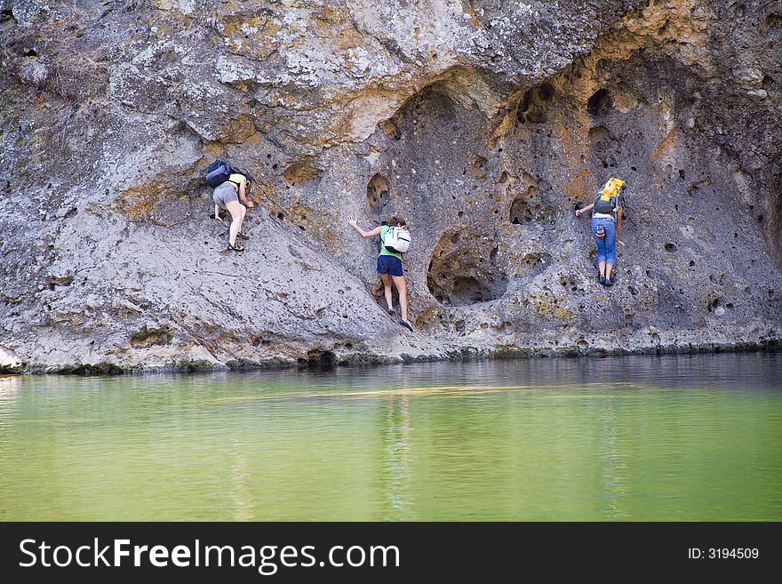 Climbers traversing rockwall